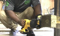 Crew Member Drilling Into Boardwalk