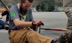 Adult Conservation Crew Member Blake Garrison Sharpening A Tool